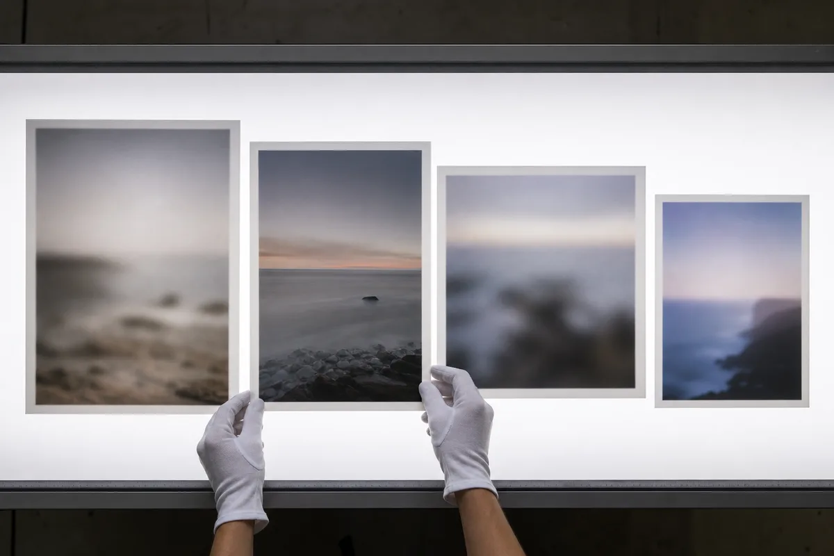 Table lumineuse d&rsquo;atelier avec plusieurs épreuves imprimées comparées côte à côte pour juger la netteté